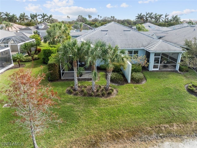 back of house with a lanai and a yard