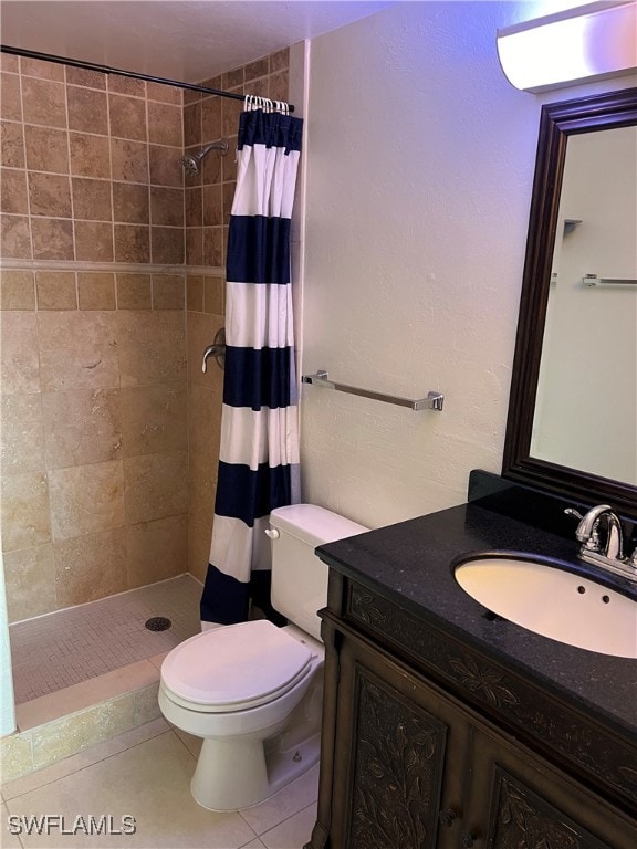 bathroom featuring toilet, vanity, a shower with shower curtain, and tile patterned floors