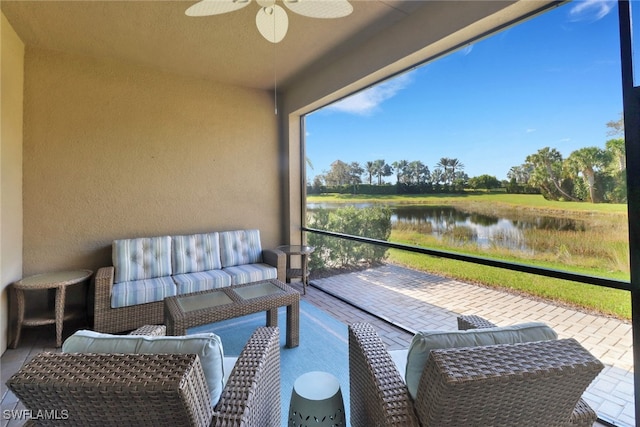 balcony with outdoor lounge area, a water view, and ceiling fan