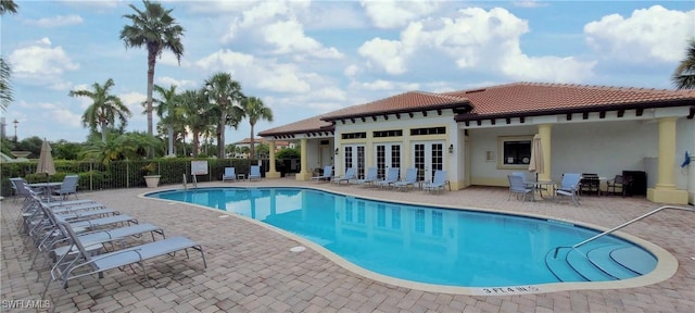 view of swimming pool with french doors and a patio