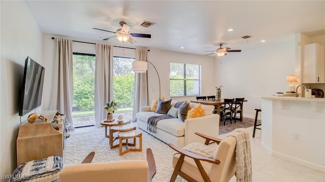 living room featuring sink, light tile patterned floors, and ceiling fan