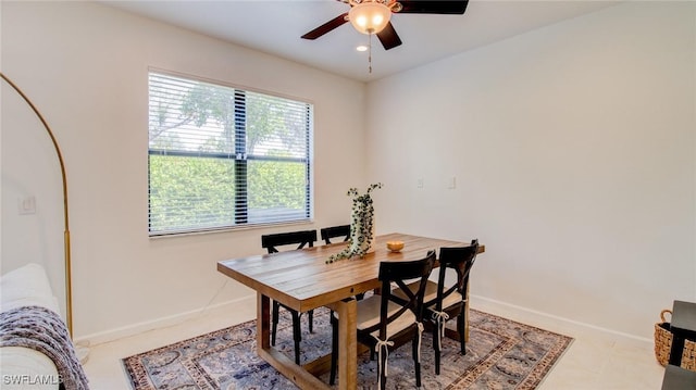 tiled dining space with ceiling fan