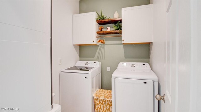 laundry area with cabinets and washing machine and clothes dryer