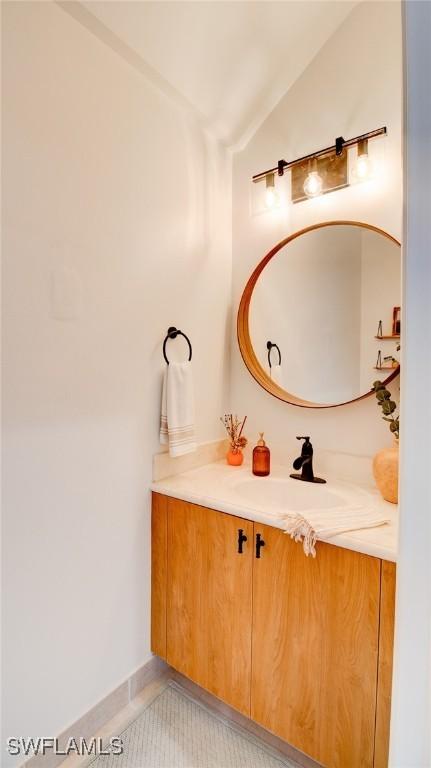 bathroom featuring lofted ceiling, vanity, and tile patterned flooring