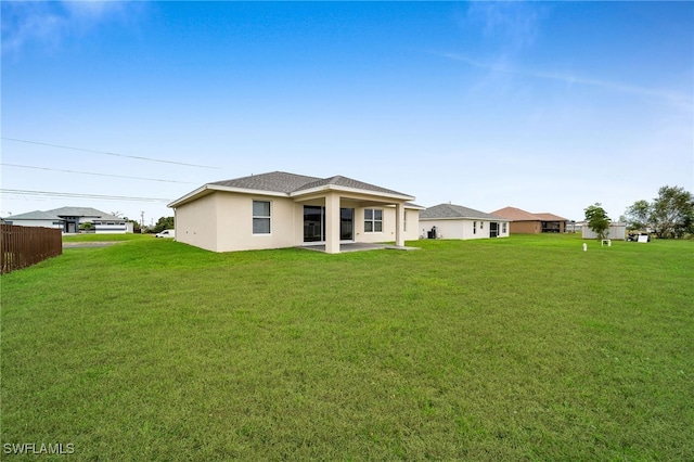 rear view of property with a lawn and a patio area