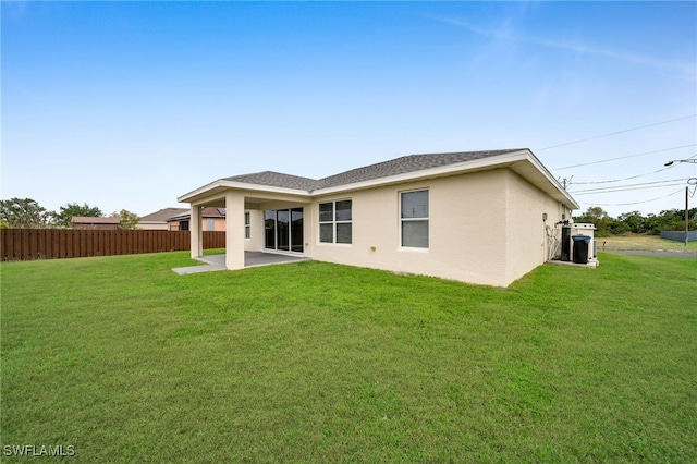 rear view of property featuring a patio area and a yard