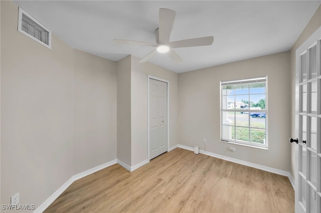 unfurnished bedroom featuring light wood-type flooring, ceiling fan, and a closet