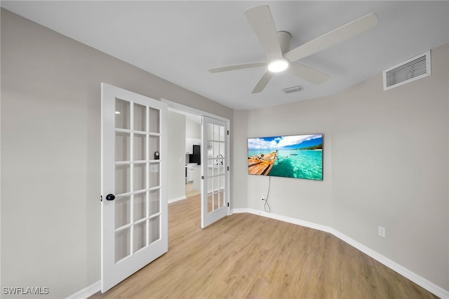 spare room featuring french doors, light wood-type flooring, and ceiling fan