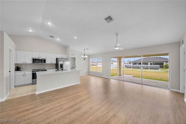 kitchen with white cabinets, light wood-type flooring, appliances with stainless steel finishes, and hanging light fixtures