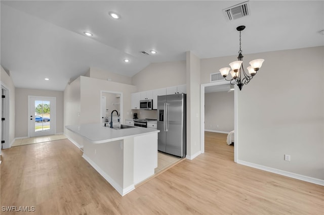 kitchen featuring vaulted ceiling, white cabinetry, light hardwood / wood-style floors, and appliances with stainless steel finishes