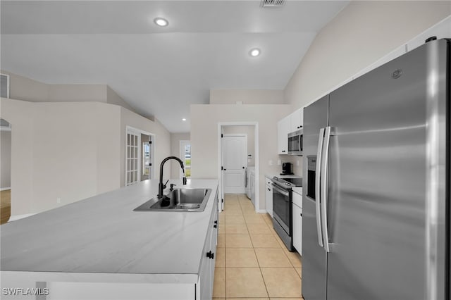 kitchen featuring a center island with sink, stainless steel appliances, white cabinetry, sink, and vaulted ceiling