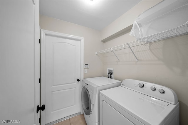 clothes washing area featuring separate washer and dryer and light tile patterned floors