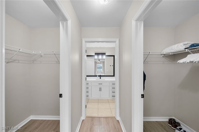 walk in closet with sink and light wood-type flooring