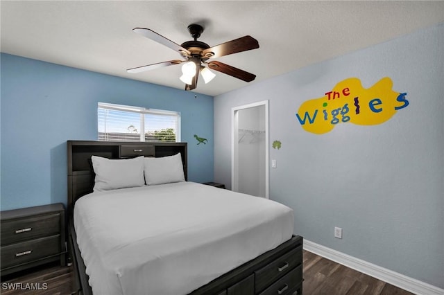 bedroom featuring a spacious closet, a closet, ceiling fan, and dark hardwood / wood-style floors