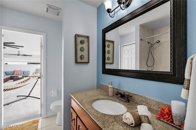 bathroom featuring tiled shower, tile patterned flooring, vanity, and toilet