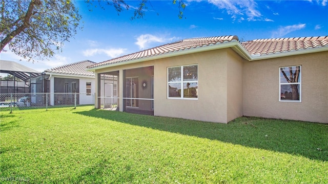 back of property with a yard and a sunroom