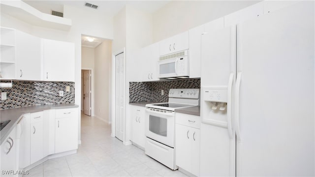 kitchen featuring decorative backsplash, white cabinetry, and white appliances