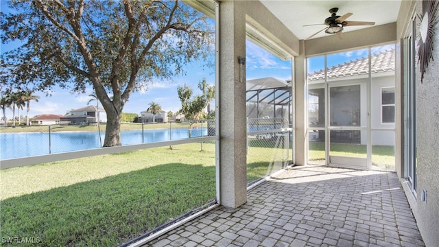 unfurnished sunroom with a water view and ceiling fan