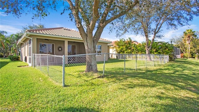 2876 Orange Grove Trl, Naples, FL 34120 - back of house featuring a ceiling fan, stucco siding, and a tiled roof