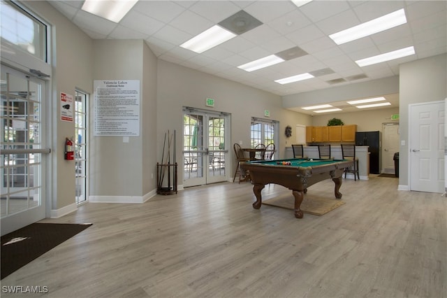 recreation room featuring a drop ceiling, light wood-type flooring, billiards, and french doors