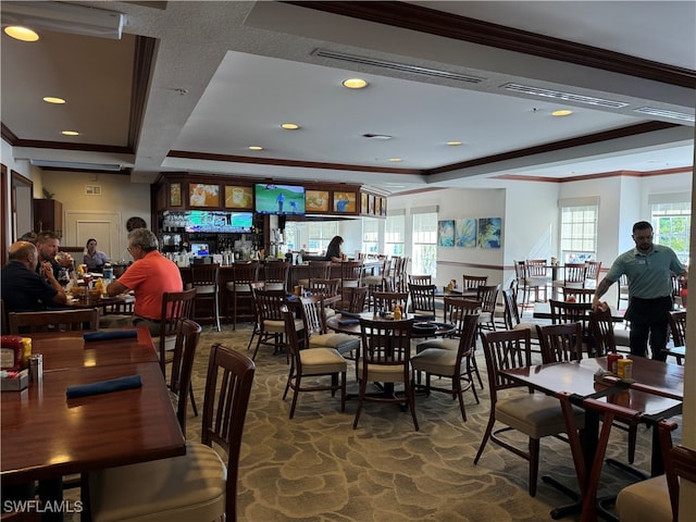 carpeted dining space featuring crown molding