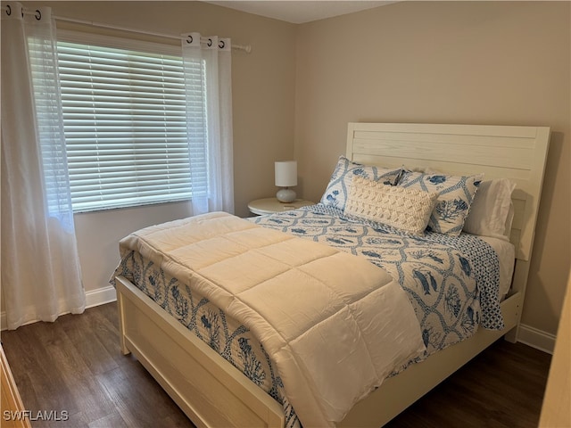 bedroom with dark hardwood / wood-style floors