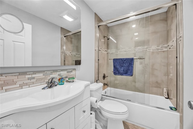 full bathroom featuring shower / bath combination with glass door, vanity, toilet, and tasteful backsplash