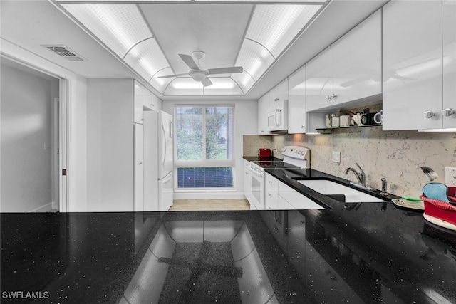 kitchen with white cabinetry, a raised ceiling, sink, white appliances, and ceiling fan