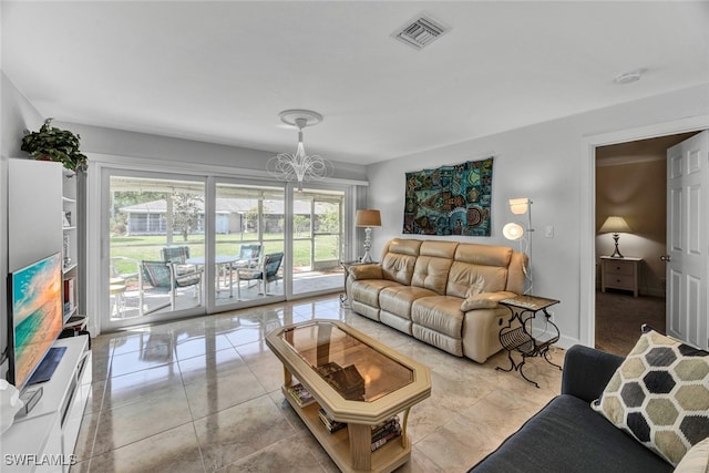 living room with light tile patterned floors and an inviting chandelier