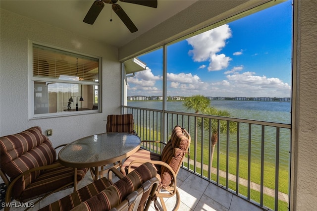 sunroom / solarium with a water view and ceiling fan