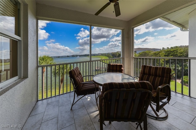 sunroom / solarium featuring a water view, a wealth of natural light, and ceiling fan