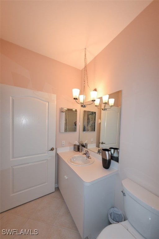 bathroom featuring toilet, tile patterned flooring, vanity, and a notable chandelier