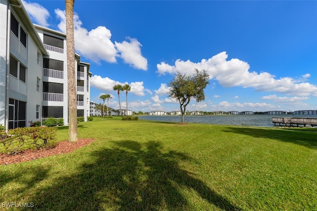 view of property's community with a yard and a water view