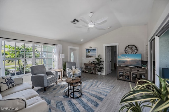 living room with a wealth of natural light, wood-type flooring, vaulted ceiling, and ceiling fan