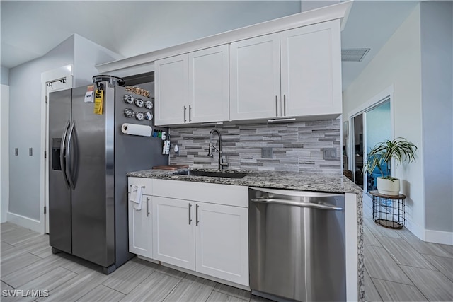 kitchen featuring sink, stainless steel appliances, backsplash, stone countertops, and white cabinets