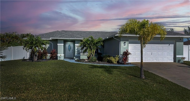 ranch-style home with a garage and a lawn