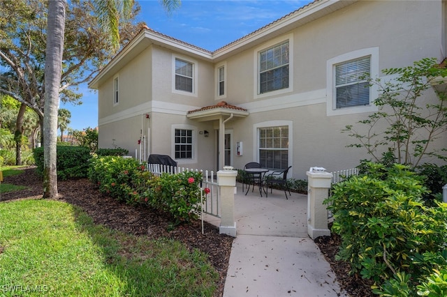 7576 Oleander Gate Dr Unit 101, Naples, FL 34109 - mediterranean / spanish home featuring a patio, stucco siding, and a tile roof