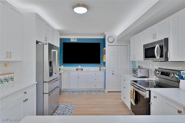 kitchen with white cabinetry, appliances with stainless steel finishes, and light wood-type flooring