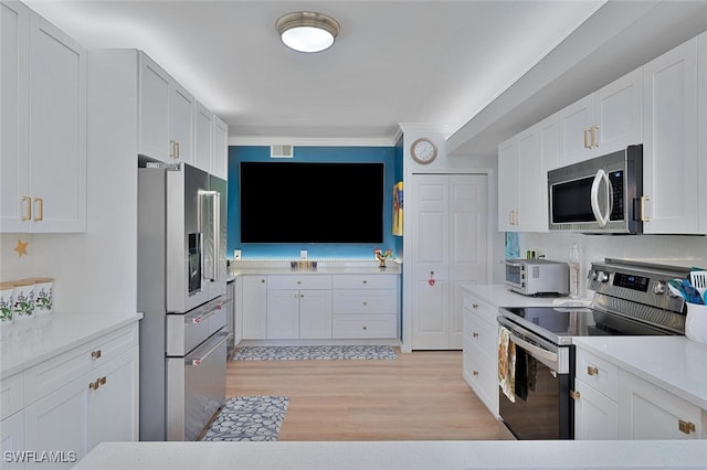 7576 Oleander Gate Dr Unit 101, Naples, FL 34109 - kitchen featuring appliances with stainless steel finishes, light wood-style floors, white cabinetry, light countertops, and ornamental molding