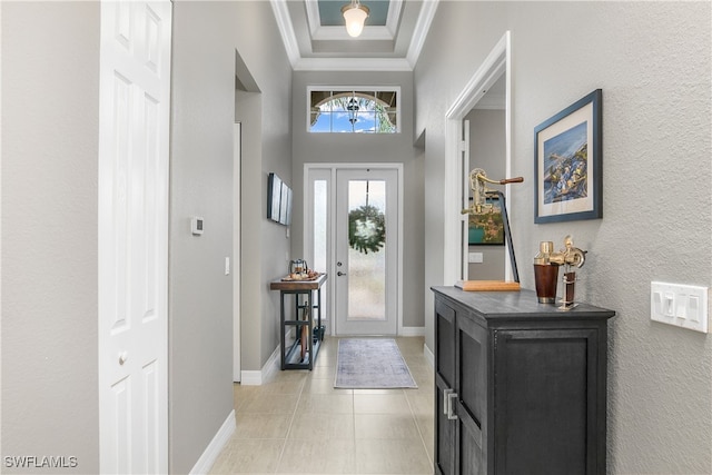 tiled foyer with a high ceiling and crown molding