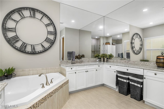 bathroom with shower with separate bathtub, vanity, and tile patterned floors