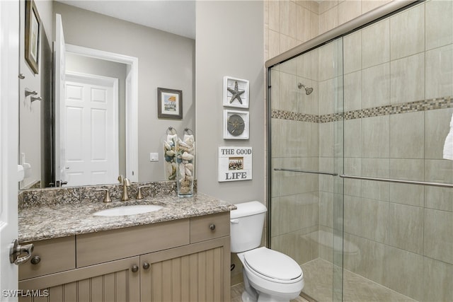 bathroom featuring walk in shower, vanity, and toilet