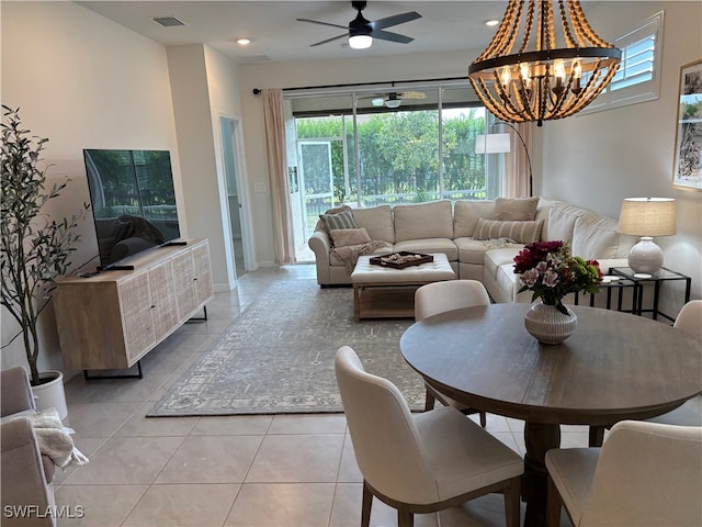 tiled living room with ceiling fan with notable chandelier