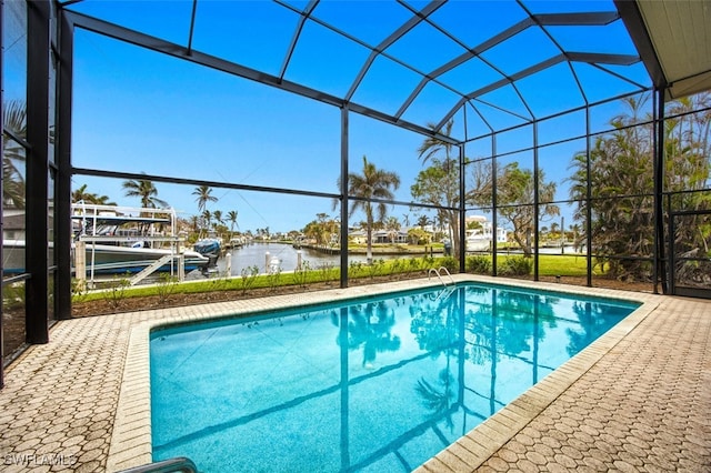 view of pool with glass enclosure, a patio area, a water view, and a boat dock