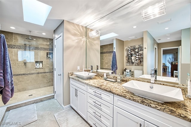 bathroom with vanity, a skylight, and tiled shower