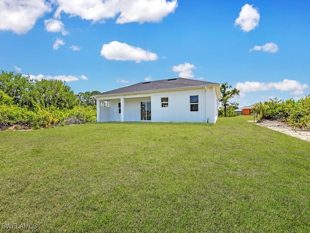 rear view of property with a lawn