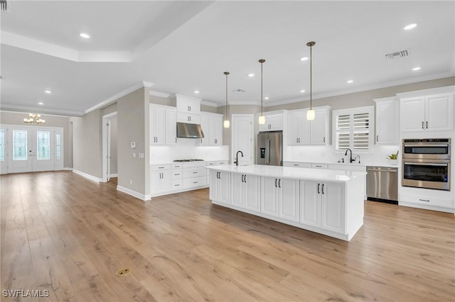 kitchen featuring pendant lighting, a center island, light wood-type flooring, and stainless steel appliances