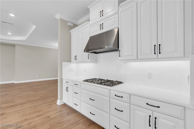 kitchen featuring stainless steel gas cooktop, white cabinets, ornamental molding, and light wood-type flooring