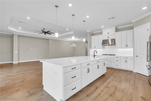 kitchen with sink, hanging light fixtures, gas cooktop, a kitchen island with sink, and light wood-type flooring