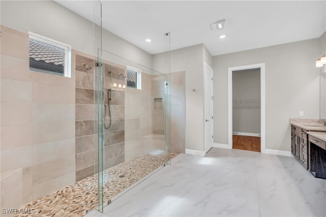 bathroom featuring vanity and tiled shower